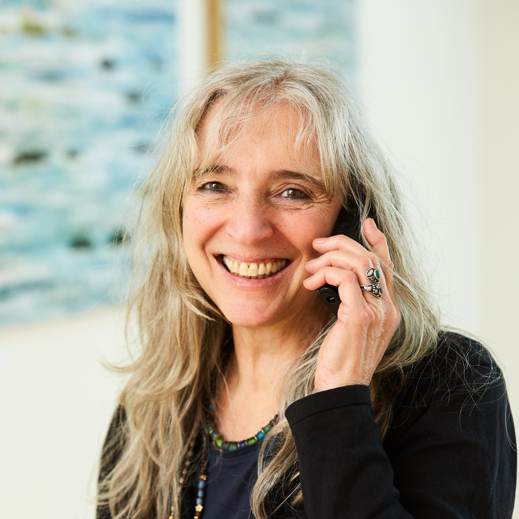 Portrait von Mitarbeiterin Cornelia Kamala Strobel am Telefon