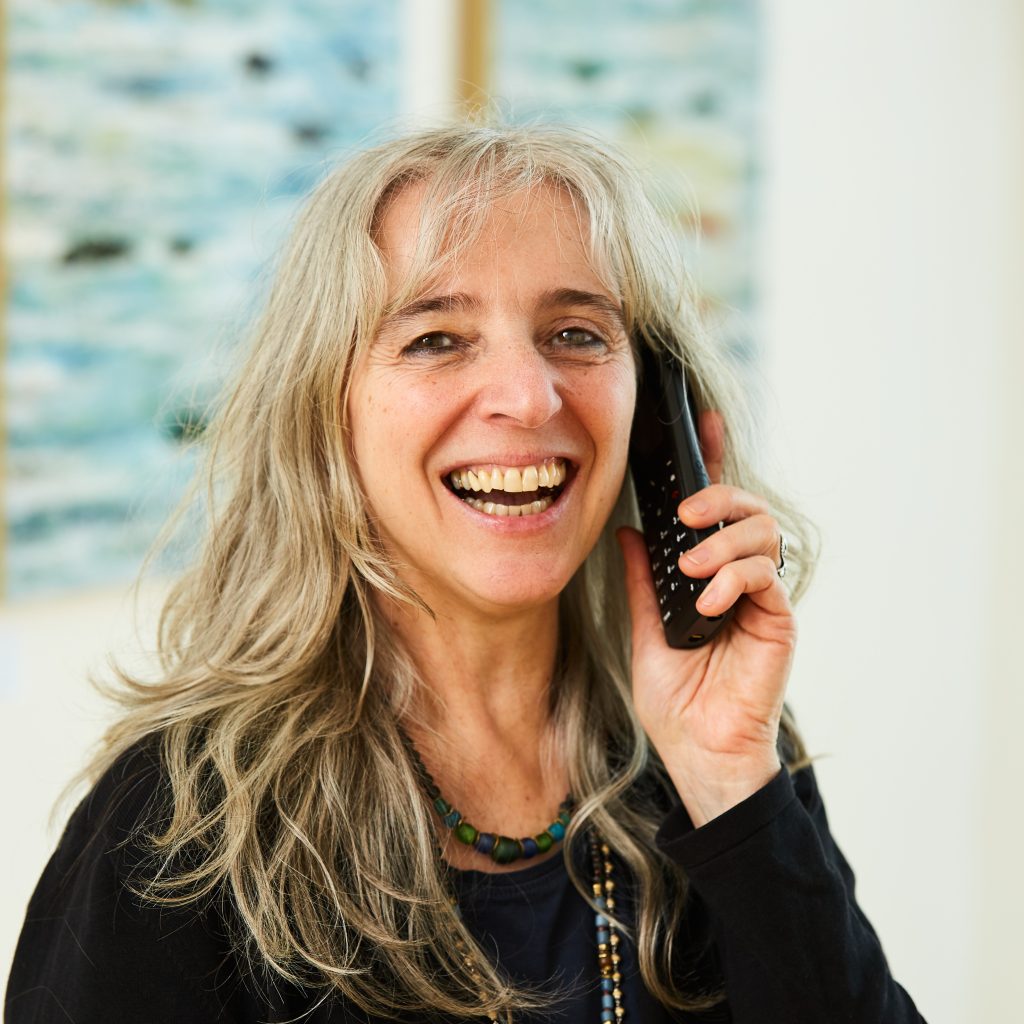 Portrait von Mitarbeiterin Cornelia Kamala Strobel am Telefon