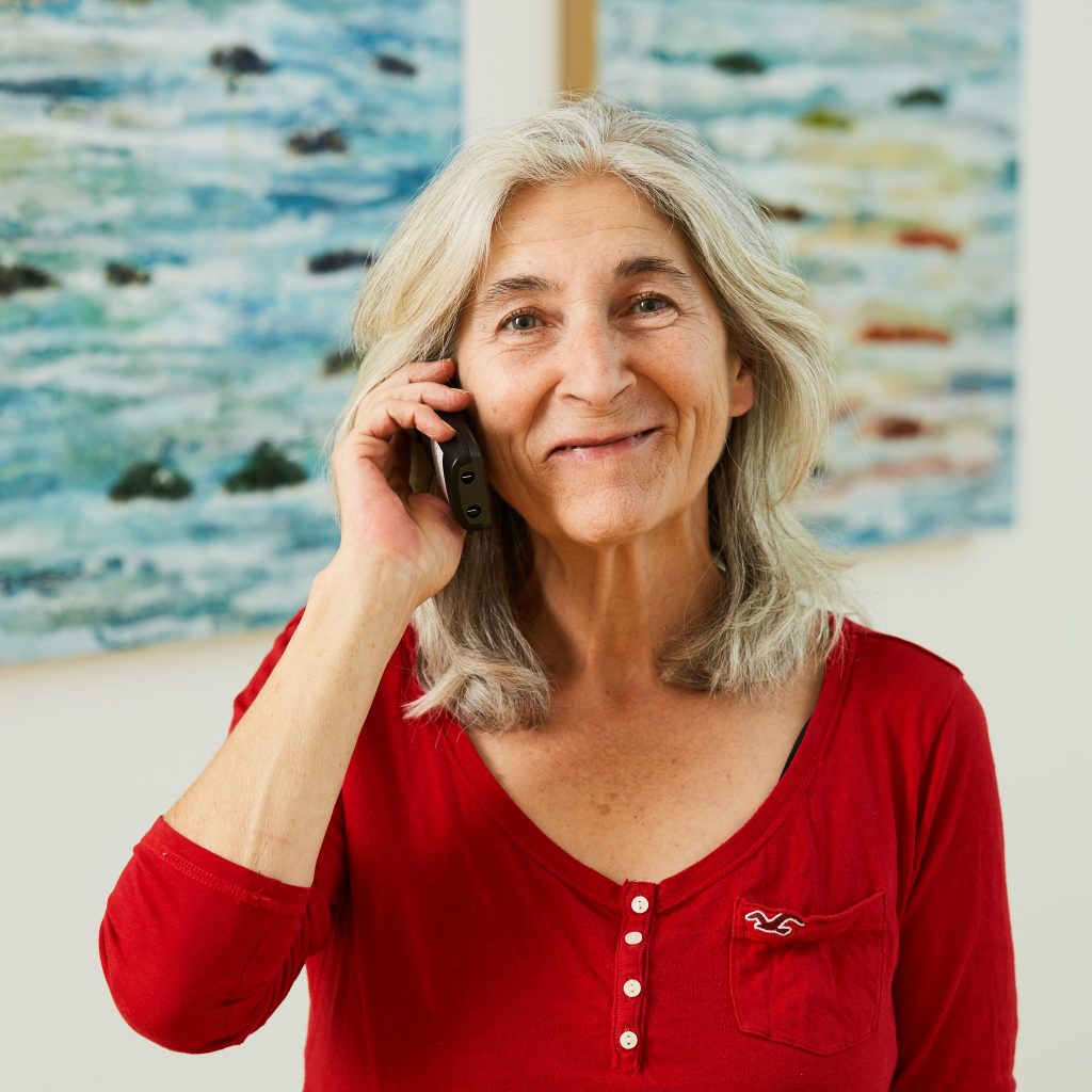 Portrait von Mitarbeiterin Claudia Hochschein am Telefon